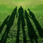 Shadow of family holding hands in park
